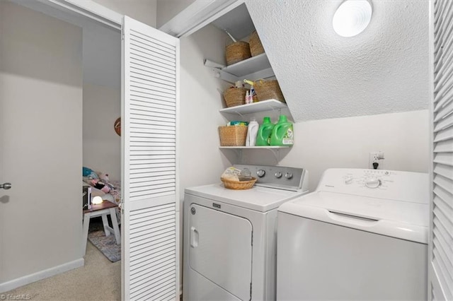 clothes washing area featuring washer and clothes dryer, laundry area, light colored carpet, and baseboards