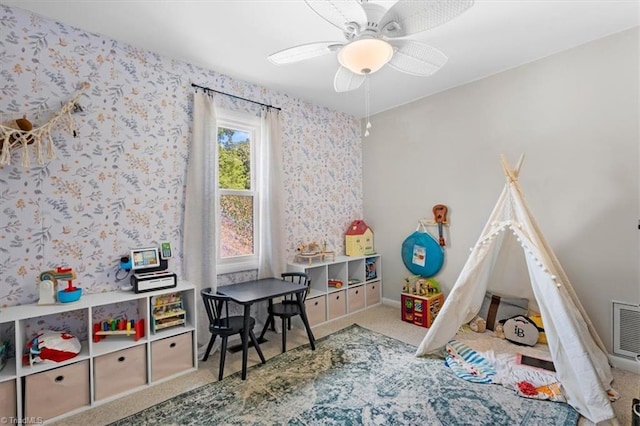 playroom with carpet, visible vents, a ceiling fan, baseboards, and wallpapered walls