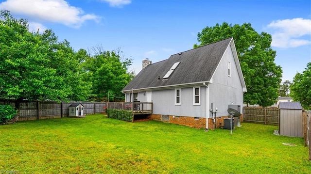 back of property featuring a storage shed, a yard, crawl space, and a fenced backyard