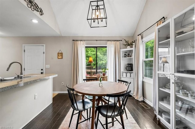 dining area with a notable chandelier, recessed lighting, baseboards, dark wood-style flooring, and vaulted ceiling