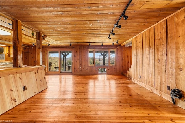 unfurnished living room featuring track lighting, light hardwood / wood-style flooring, and wood ceiling