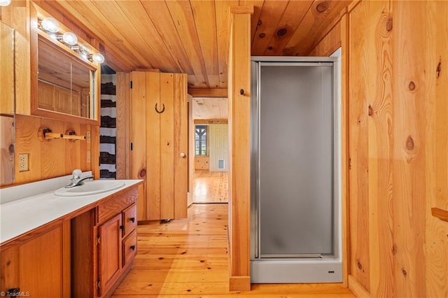 bathroom with hardwood / wood-style floors, wood walls, wooden ceiling, and walk in shower