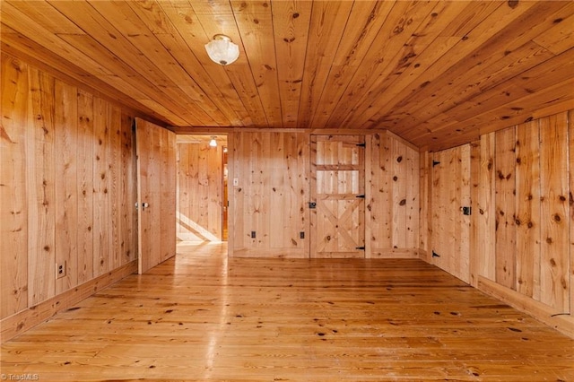 additional living space with vaulted ceiling, light hardwood / wood-style flooring, wooden walls, and wood ceiling