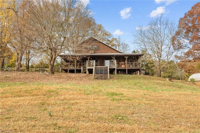 view of front of property with a wooden deck and a front lawn