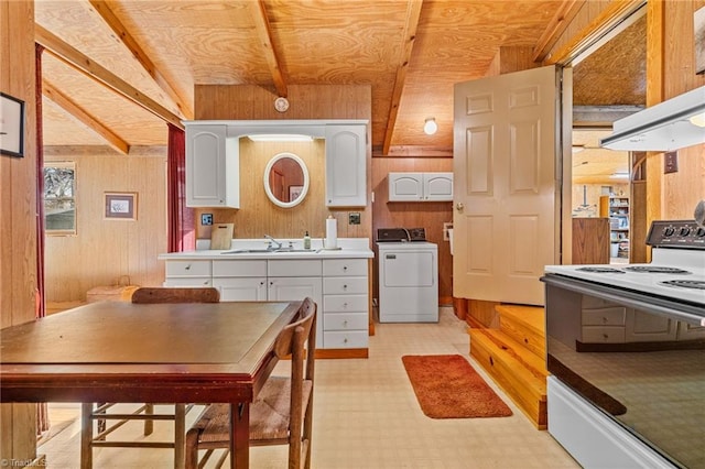 kitchen featuring sink, washer / clothes dryer, white range with electric cooktop, wooden walls, and white cabinets