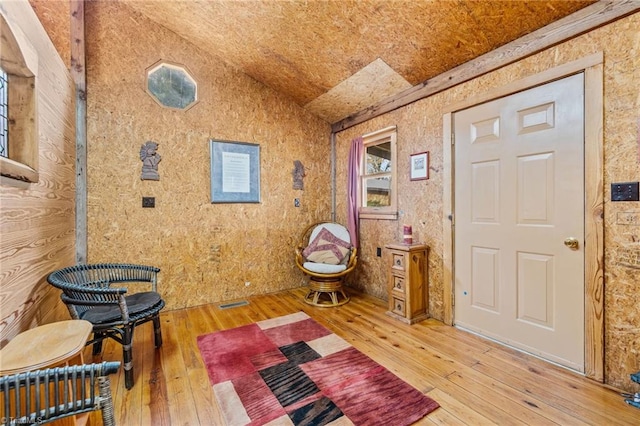 sitting room with hardwood / wood-style floors and lofted ceiling