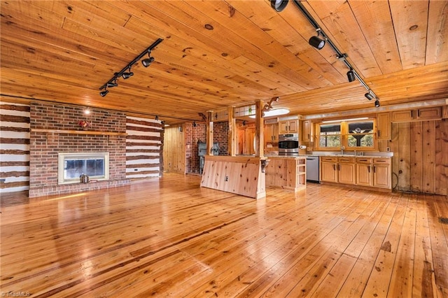 unfurnished living room with a brick fireplace, wood walls, light hardwood / wood-style floors, track lighting, and wood ceiling