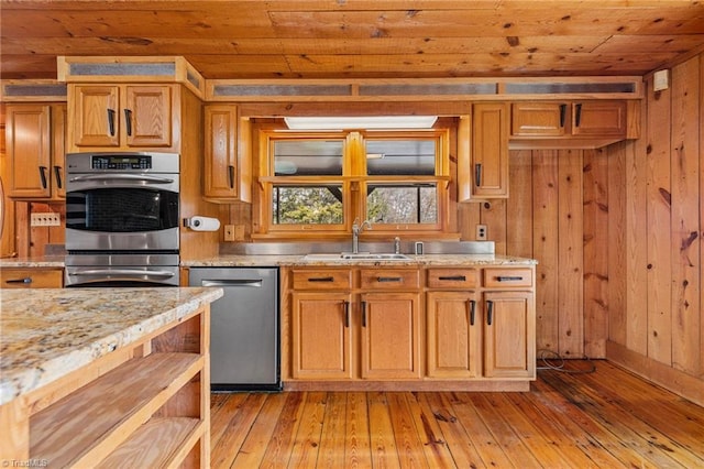 kitchen with sink, dishwasher, wooden ceiling, wood walls, and light wood-type flooring