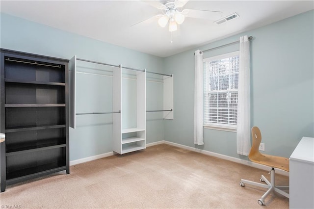 unfurnished office featuring ceiling fan and light carpet