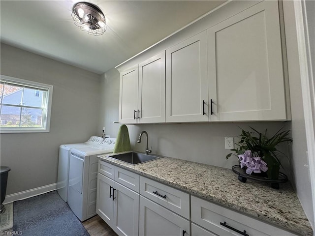 laundry area with sink, washing machine and dryer, and cabinets