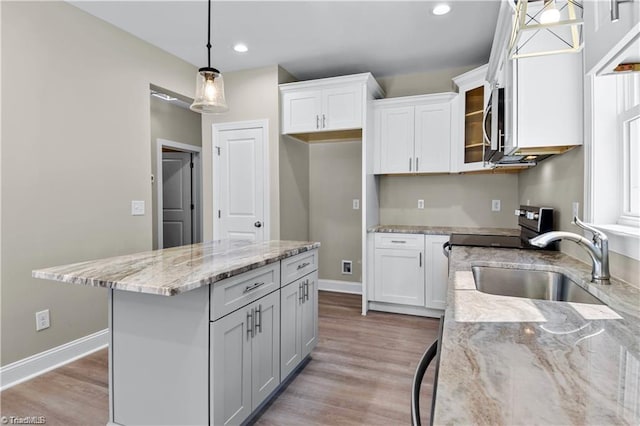 kitchen with white cabinets, pendant lighting, a center island, and sink