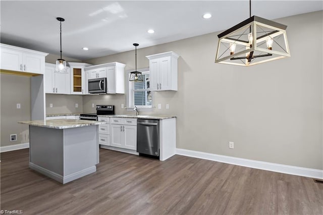 kitchen with pendant lighting, a center island, stainless steel appliances, and white cabinetry