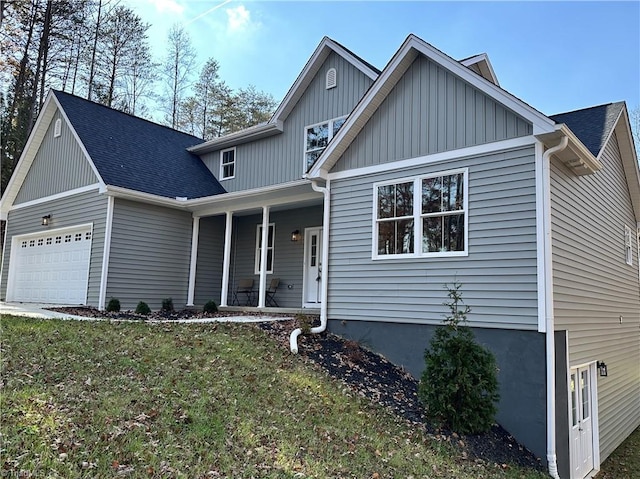 view of front of house with covered porch, a garage, and a front lawn