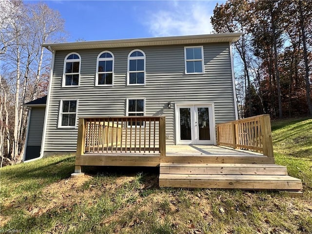 back of house featuring a lawn, a wooden deck, and french doors