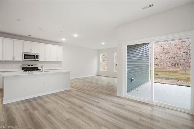 5365 Roshni Ter, Mcleansville, NC 27301 - kitchen with light wood-style floors, recessed lighting, light countertops, stainless steel appliances, and open floor plan