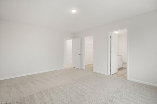 5365 Roshni Ter, Mcleansville, NC 27301 - unfurnished bedroom with a closet, a spacious closet, light colored carpet, and baseboards
