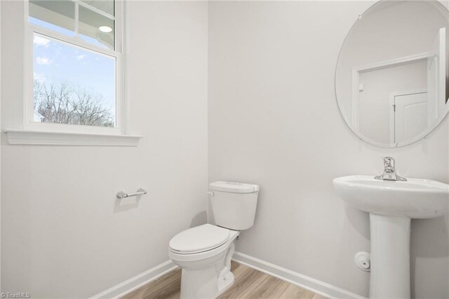 5365 Roshni Ter, Mcleansville, NC 27301 - half bathroom featuring toilet, baseboards, wood finished floors, and a sink