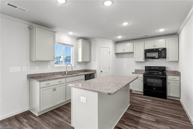 kitchen featuring dark wood-type flooring, ornamental molding, visible vents, black appliances, and a sink