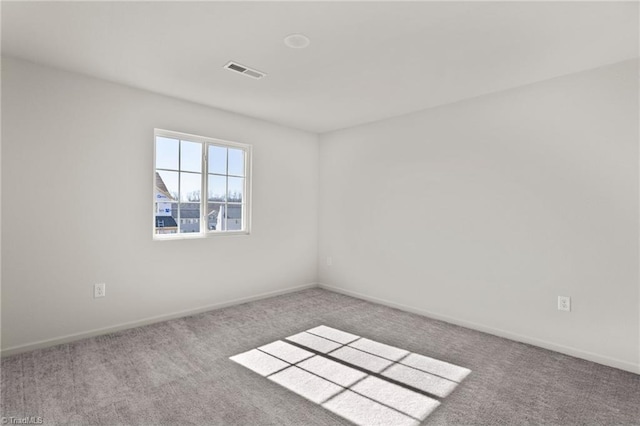 unfurnished room with visible vents, baseboards, and carpet