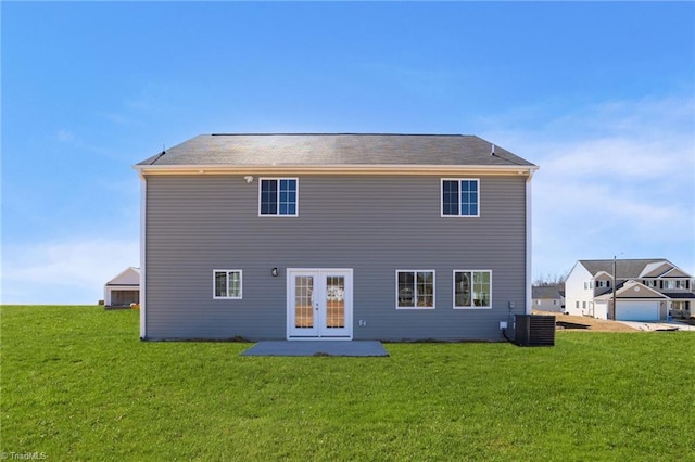 rear view of house with a yard, central AC unit, and french doors