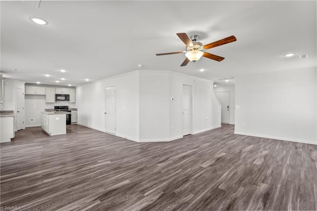 unfurnished living room featuring baseboards, ornamental molding, recessed lighting, a ceiling fan, and dark wood finished floors