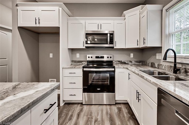 307 Lick Creek Church Rd, Denton, NC 27239 - kitchen featuring stainless steel appliances, a sink, wood finished floors, white cabinets, and light stone counters