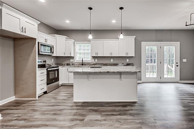 307 Lick Creek Church Rd, Denton, NC 27239 - kitchen featuring appliances with stainless steel finishes, a kitchen island, white cabinetry, light stone counters, and recessed lighting
