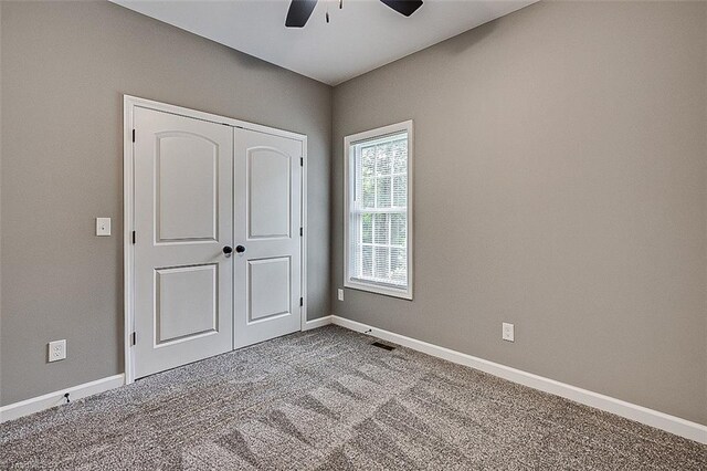 307 Lick Creek Church Rd, Denton, NC 27239 - unfurnished bedroom featuring carpet floors, a closet, baseboards, and a ceiling fan