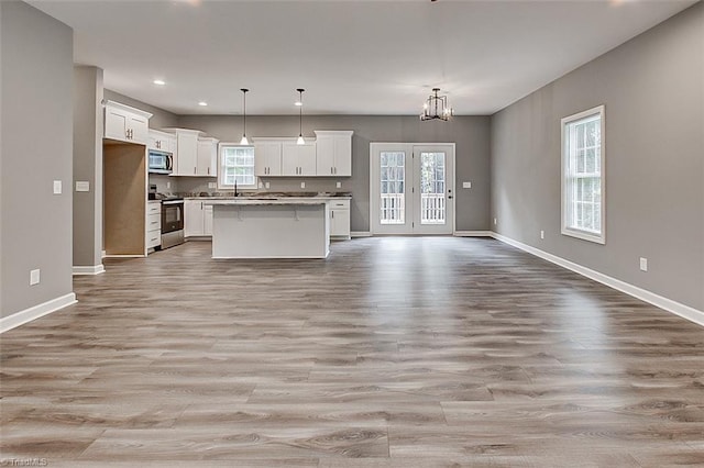307 Lick Creek Church Rd, Denton, NC 27239 - kitchen with open floor plan, appliances with stainless steel finishes, light wood-style flooring, white cabinets, and baseboards