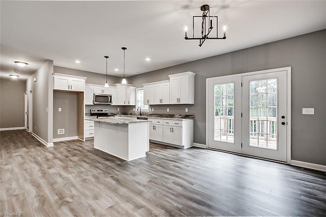 307 Lick Creek Church Rd, Denton, NC 27239 - kitchen featuring stainless steel microwave, electric range, baseboards, white cabinets, and a kitchen island