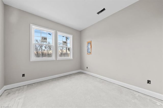 empty room with visible vents, concrete floors, and baseboards