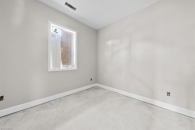 spare room with concrete floors and baseboards