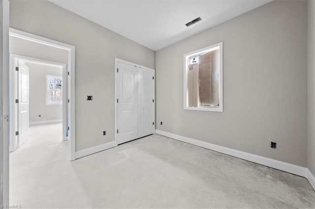 unfurnished bedroom featuring concrete flooring, visible vents, and baseboards