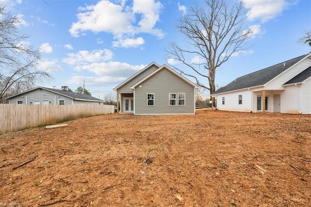 rear view of house featuring fence