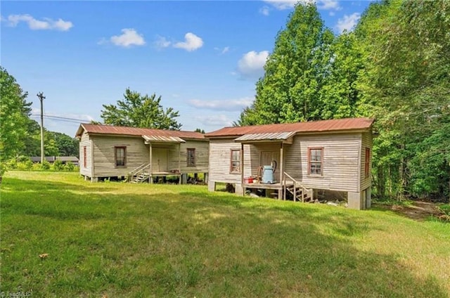 rear view of house featuring a lawn