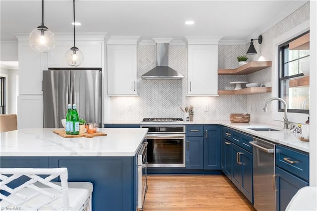 306 W Greenway Dr S, Greensboro, NC 27403 - kitchen featuring appliances with stainless steel finishes, wall chimney exhaust hood, blue cabinets, a sink, and ornamental molding