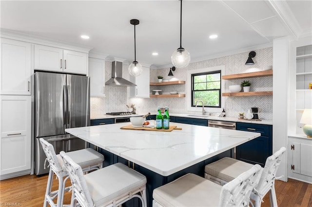 306 W Greenway Dr S, Greensboro, NC 27403 - kitchen featuring stainless steel appliances, wall chimney range hood, open shelves, wood finished floors, and a sink