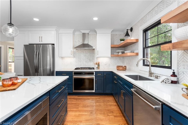 306 W Greenway Dr S, Greensboro, NC 27403 - kitchen with appliances with stainless steel finishes, wall chimney exhaust hood, blue cabinets, a sink, and open shelves