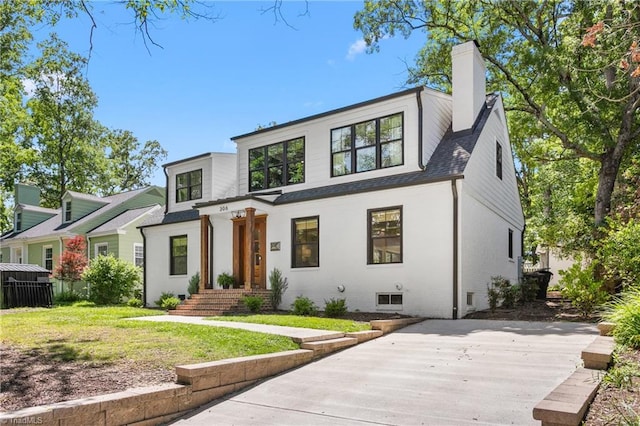 306 W Greenway Dr S, Greensboro, NC 27403 - view of front facade featuring roof with shingles, a front yard, and a chimney