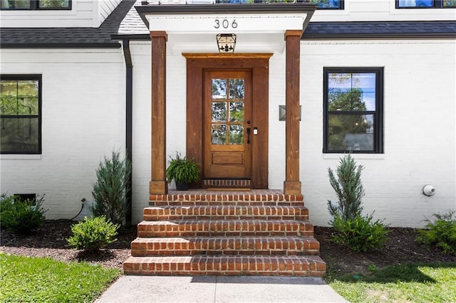 306 W Greenway Dr S, Greensboro, NC 27403 - view of exterior entry with brick siding and a shingled roof