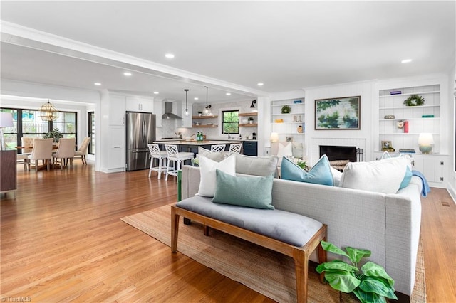 306 W Greenway Dr S, Greensboro, NC 27403 - living area featuring a brick fireplace, plenty of natural light, a chandelier, light wood-style floors, and recessed lighting