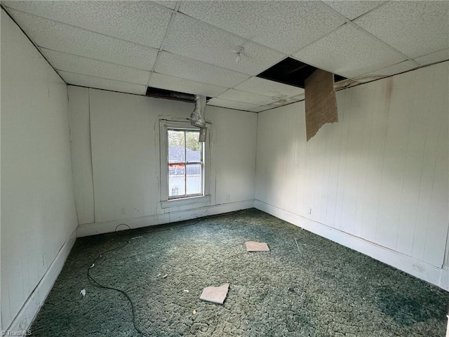 carpeted empty room featuring a paneled ceiling