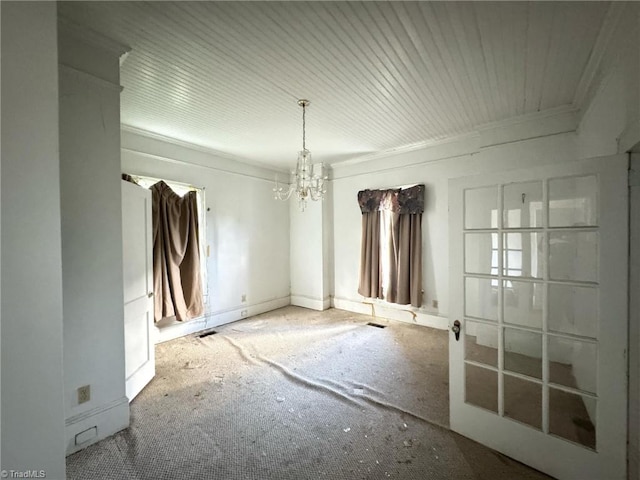 empty room with a notable chandelier, carpet, and crown molding