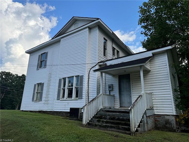 rear view of property with a lawn