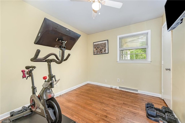 workout area with wood finished floors, visible vents, ceiling fan, and baseboards