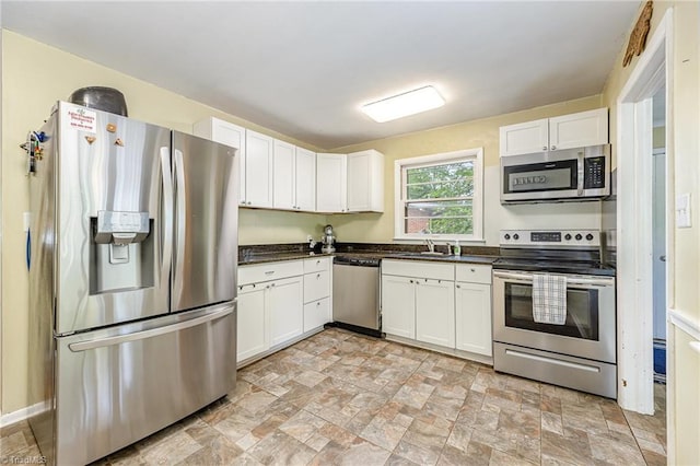 kitchen with white cabinets, dark countertops, and appliances with stainless steel finishes