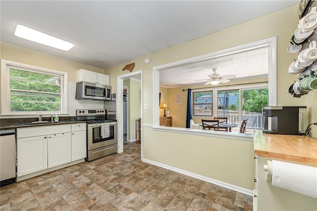 kitchen featuring white cabinets, plenty of natural light, appliances with stainless steel finishes, and a sink