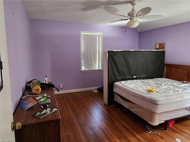 bedroom featuring ceiling fan, dark hardwood / wood-style flooring, and a textured ceiling