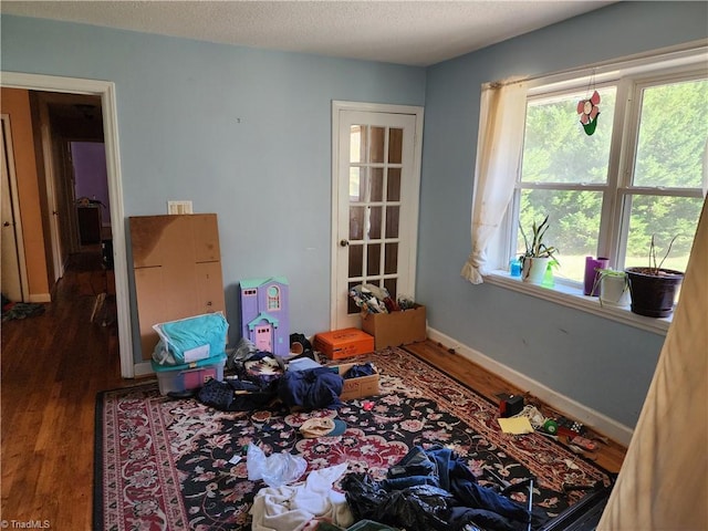 miscellaneous room featuring a textured ceiling and dark hardwood / wood-style flooring