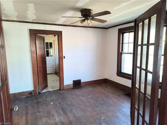 empty room with crown molding, ceiling fan, and dark hardwood / wood-style flooring